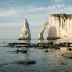 brown rock formation on body of water